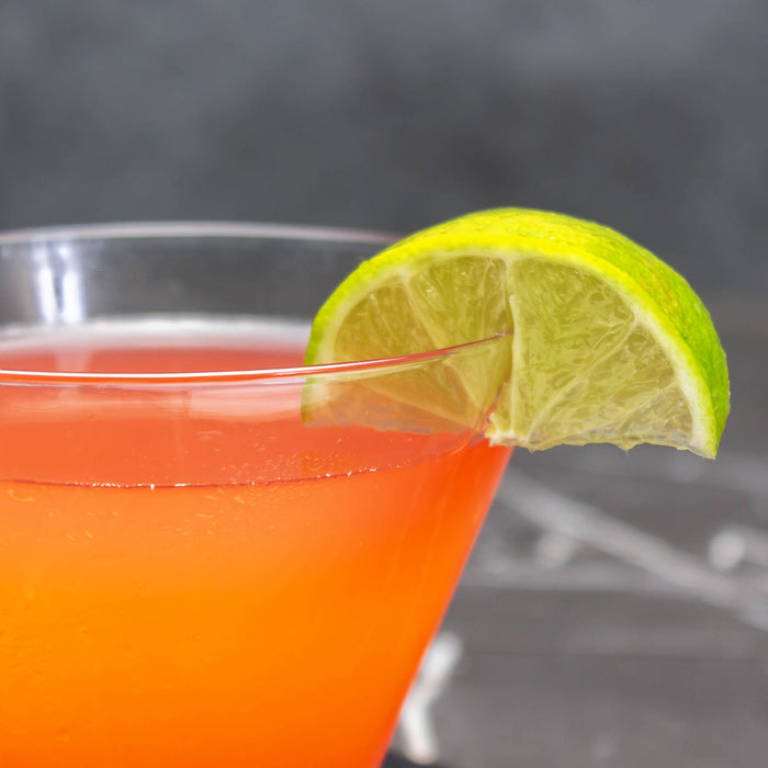 Cocktail with a lime wedge on a dark background