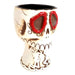 Skull-shaped mug with red eyes on a white background