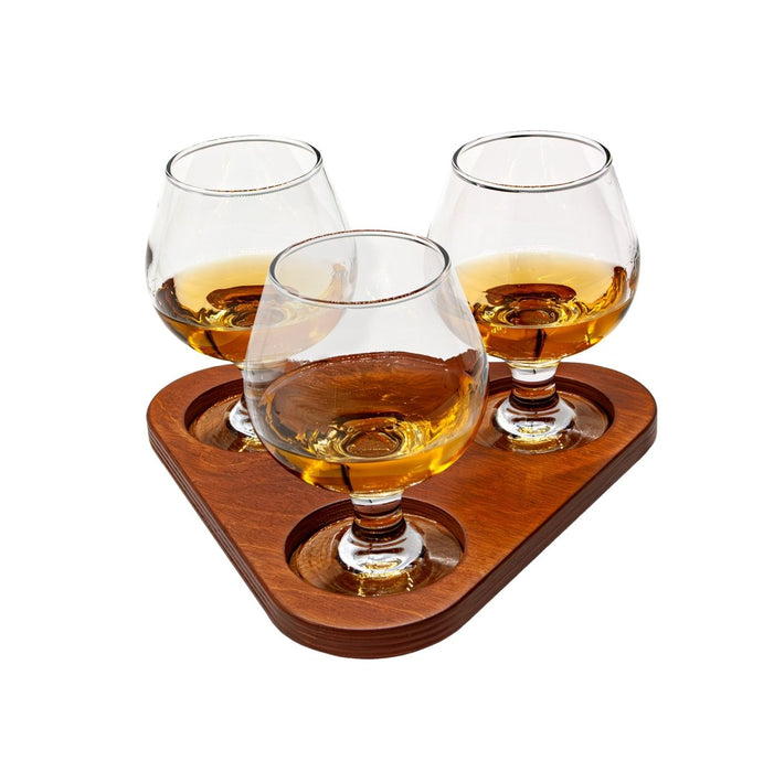 Three sniffer glasses on a cherry stain wooden tray with a white background