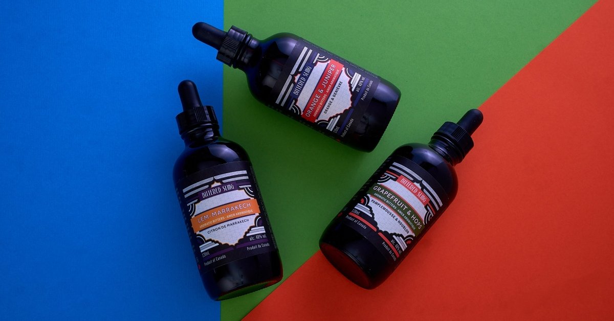 Three black bottles with droppers on a colorful geometric background