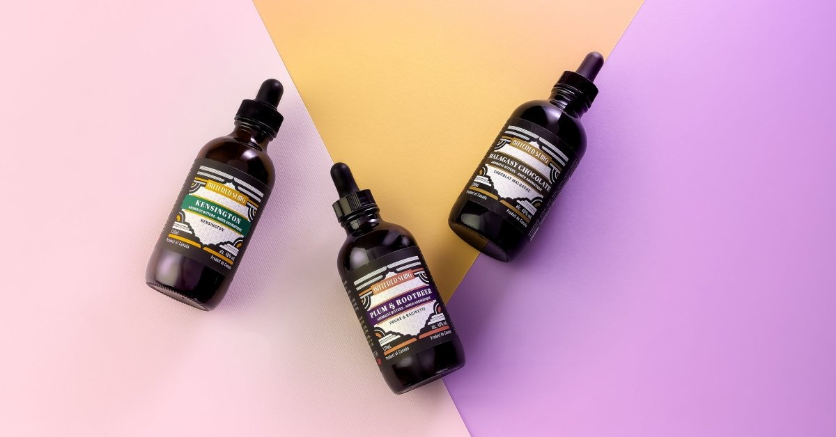 Three black dropper bottles with labels on a gradient pink and purple background