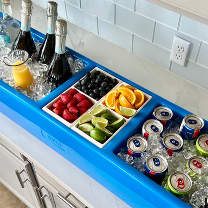 Blue drink station with bottles, fruits, and cans on a kitchen counter.