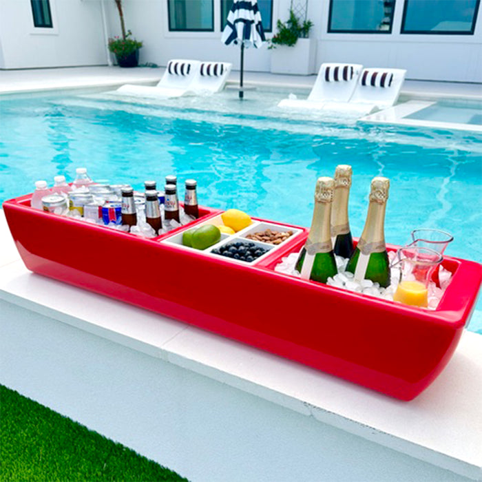 Red boat-shaped cooler with drinks and snacks by a pool