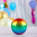 Multicolored disco ball cup with a straw on a blurred festive background