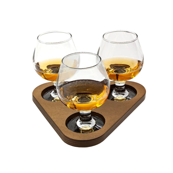 Three sniffer glasses on a stained wooden tray with a white background
