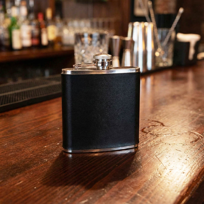 Black leather flask on a bar counter with blurred bar background