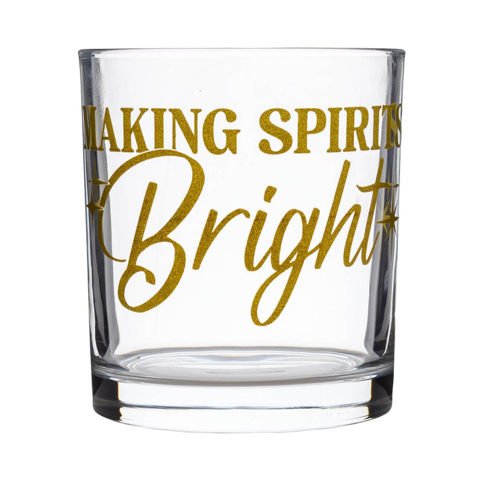 A clear glass rocks tumbler with gold foil lettering that reads 'Making Spirits Bright' on a solid white background.