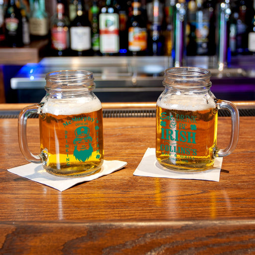 Two mason jars with beer on a bar counter, featuring two Irish Designs
