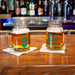 Two mason jars with beer on a bar counter, featuring two Irish Designs