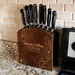 Wooden knife block with engraved names and dates on a kitchen counter.