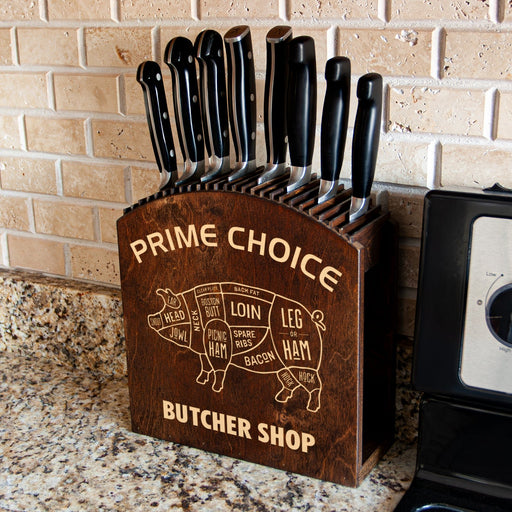 Wooden knife block with engraved butcher shop design and knives on a kitchen counter.