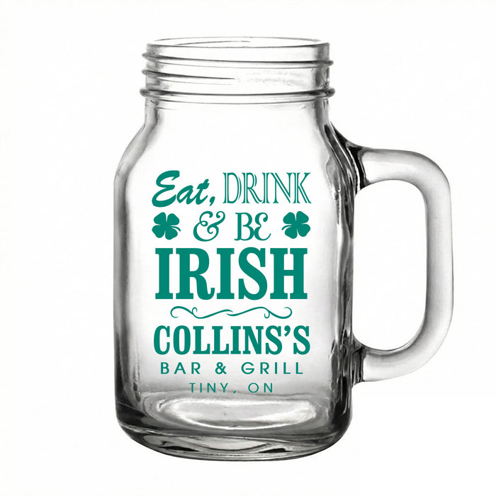 Clear glass mug with teal text 'Eat, Drink & Be Irish' and a handle on a white background