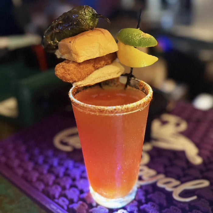 Cocktail with garnishes on a purple coaster