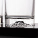 Clear glass rocks glasses with a sculpted mountain base, shown on a black surface with a white background.