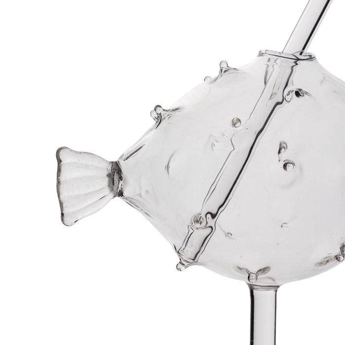 Clear glass object shaped like a fish on a white background