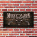 Wooden sign with 'Murphy Saloon' text and bull skull design on a brick wall background