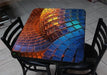 Colorful mosaic table with black chairs on a tiled floor
